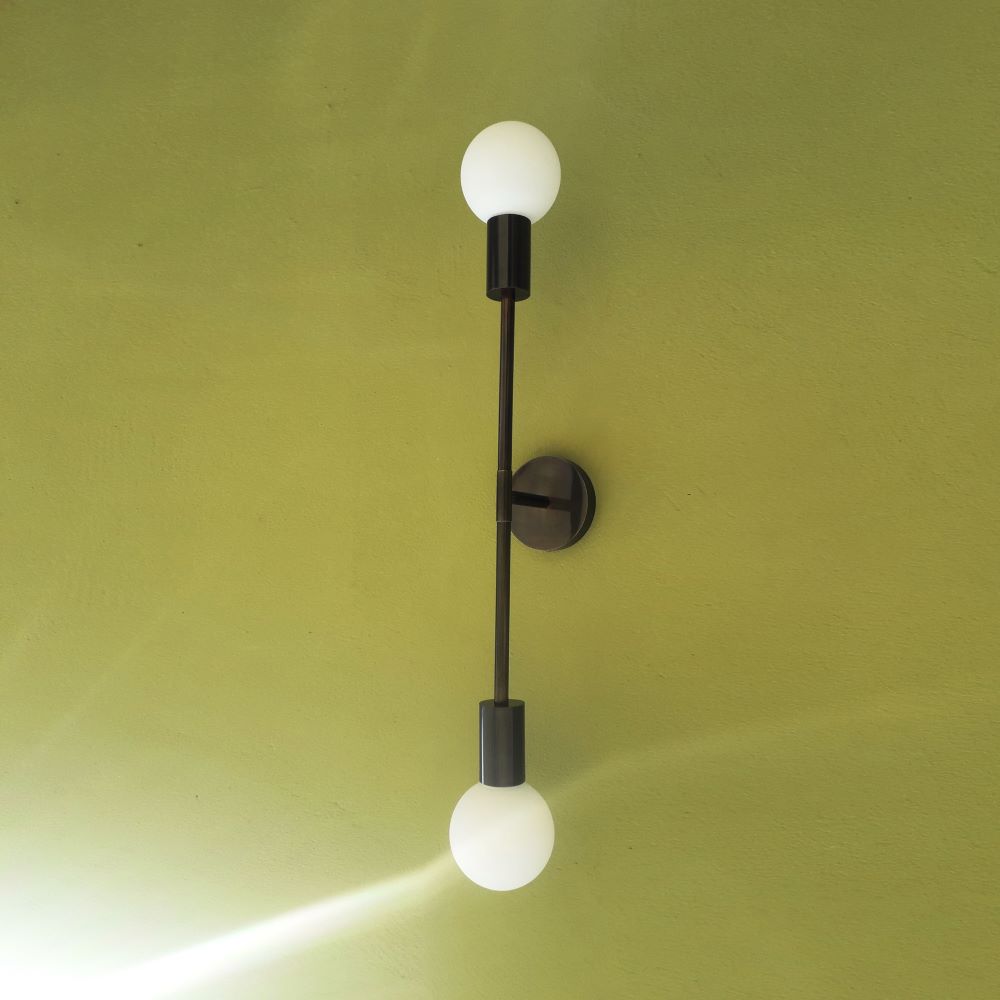 Minimalist brass wall sconce with dual light source. Aged gold or gunmetal finish. H 60 cm.
