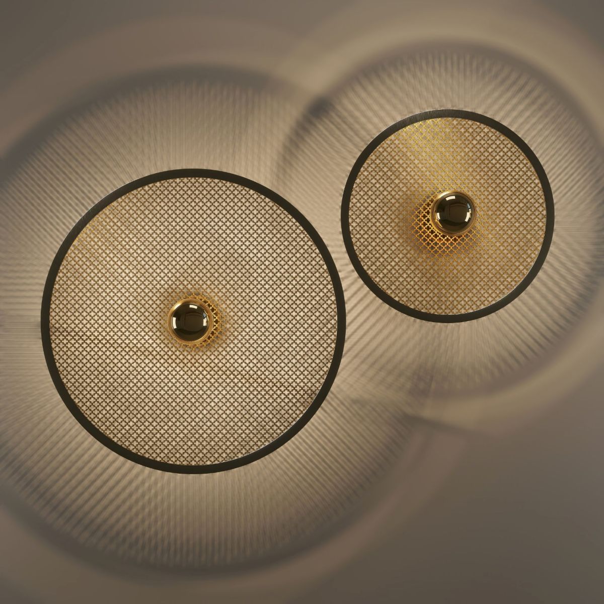 Handcrafted brass mesh wall sconce with perforated circular disc and central brass dome casting halo light